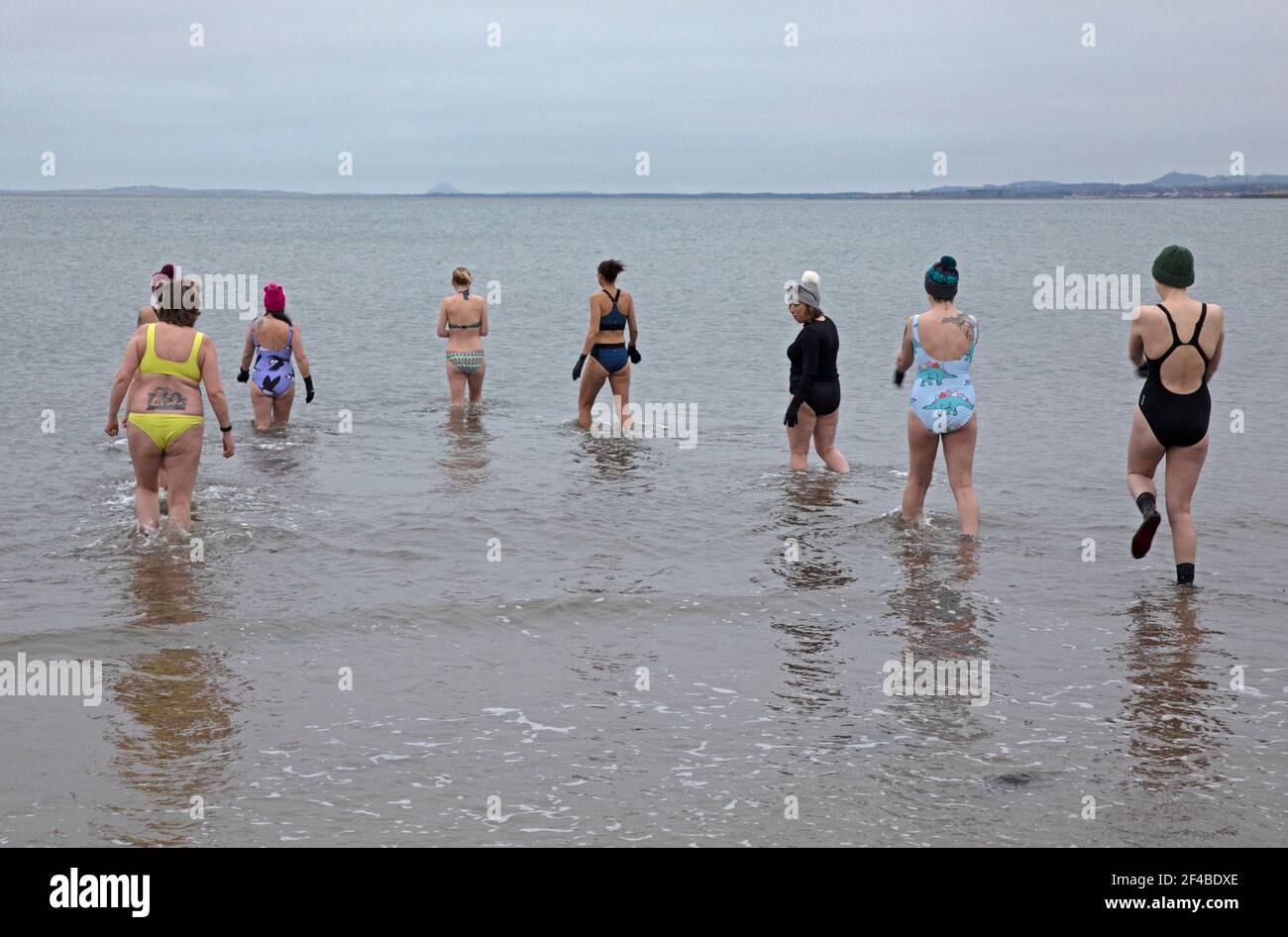 Portobello, Edimburgo, Scozia, Regno Unito. 20 Marzo 2021. L'Equinozio Vernale, durante gli Equinozi l'inclinazione della Terra (rispetto al Sole) è 0° e per la sua durata del giorno e della notte sono quasi uguali al giorno dell'Equinozio, cioè 12 ore. Nella foto: Anna of WanderWomen Scotland conduce una sessione di allenamento di nuoto con l'acqua fredda con sei donne nel Firth of Forth, completando un cerchio completo da Covid Lockdown nel marzo 2020, quando diciassette donne si unirono ad Anna per un 'bagno pring'. Il sole non appariva oggi, ma queste donne godevano ancora dell'estprerogenza della mattina presto. Credit: Arch White/Alamy Live News Foto Stock