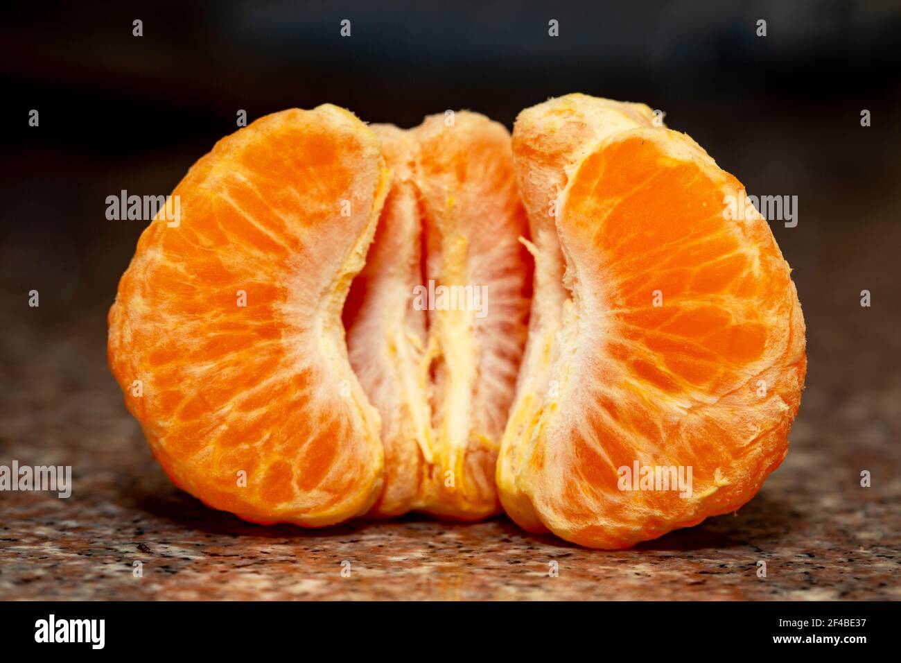 dolce mandarino sbucciato su fondo nero. Foto Stock