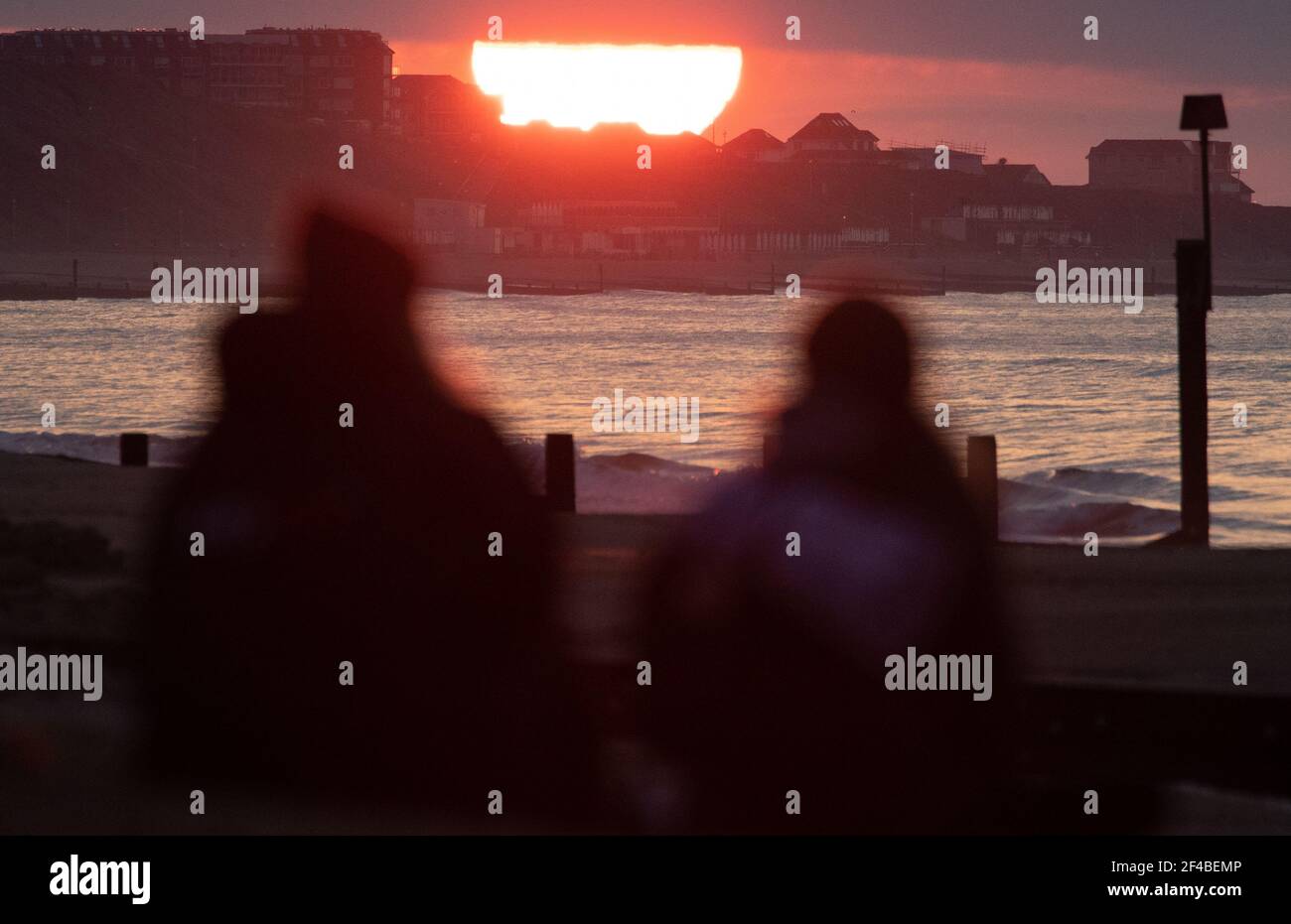 La gente guarda il sole sorgere sulla spiaggia di Boscombe a Dorset il giorno dell'equinozio di primavera. Data immagine: Sabato 20 marzo 2021. Foto Stock