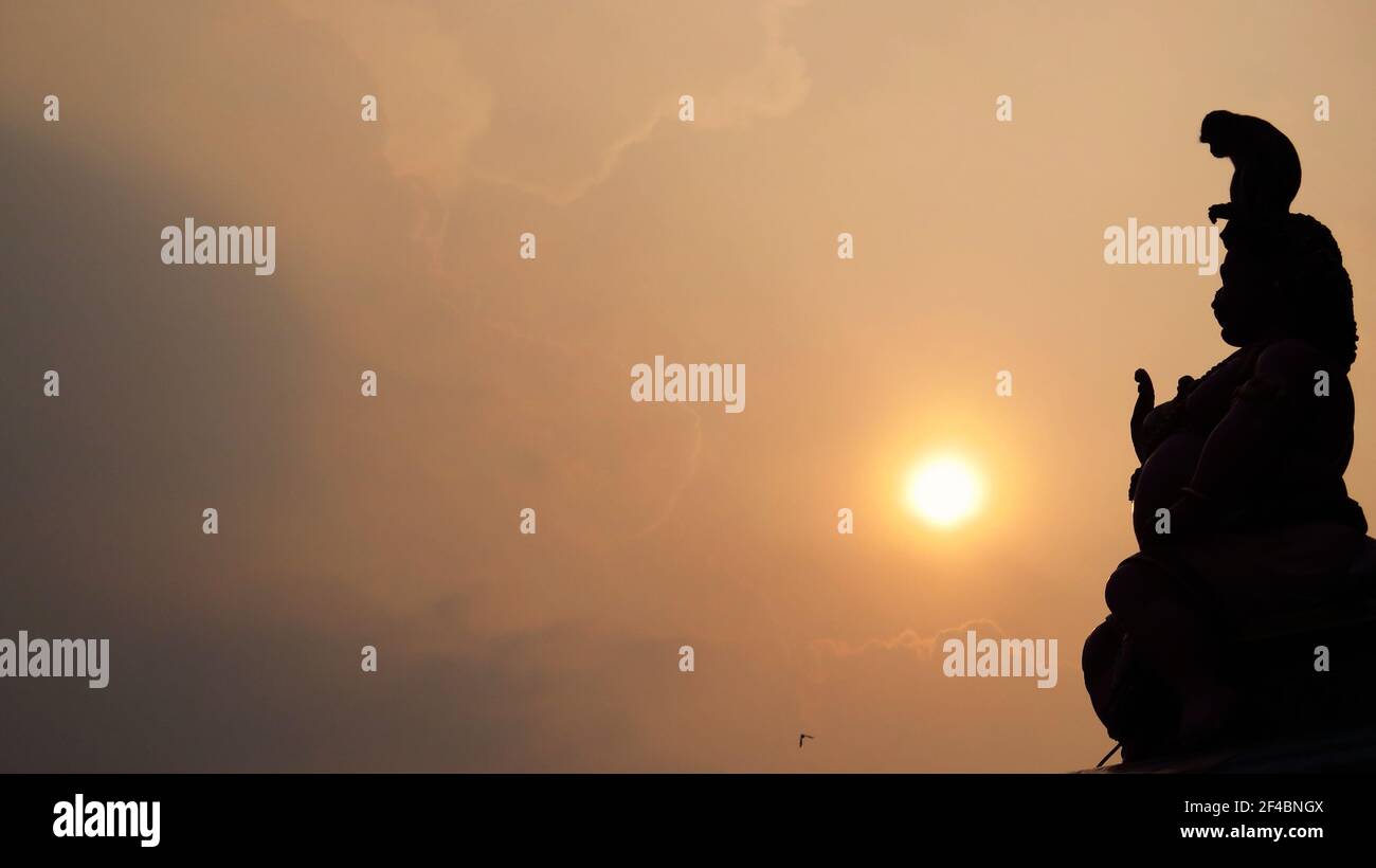 Statue indù in Silhouette al tramonto: Statue religiose alle grotte di Batu, un sito di tempio indù grotta e santuario Foto Stock