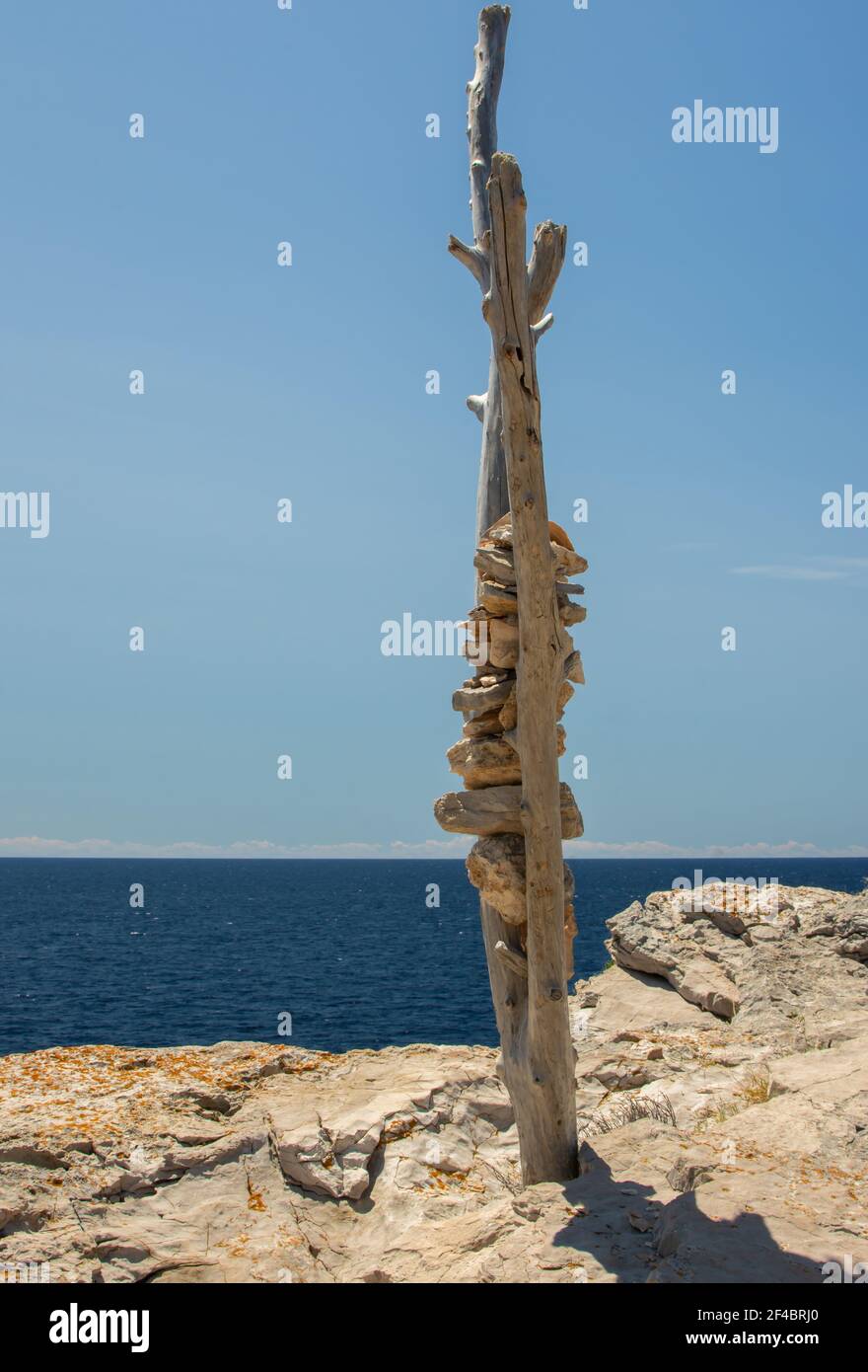 Sculture di ciottoli marini contro il mare blu e il cielo limpido. Scultura di ciottoli realizzata sulla spiaggia adriatica. Foto Stock
