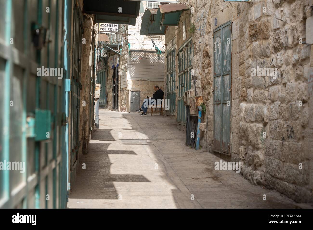 (210320) -- BETLEMME, 20 marzo 2021 (Xinhua) -- UN uomo palestinese si trova vicino a negozi chiusi nella città di Betlemme, in Cisgiordania, 20 marzo 2021. Il Governatore di Betlemme ha annunciato giovedì la chiusura del governatorato e il divieto di tutte le attività da giovedì sera a domenica mattina a causa del numero crescente di infezioni da COVID-19. (Foto di Luay Sababa/Xinhua) Foto Stock