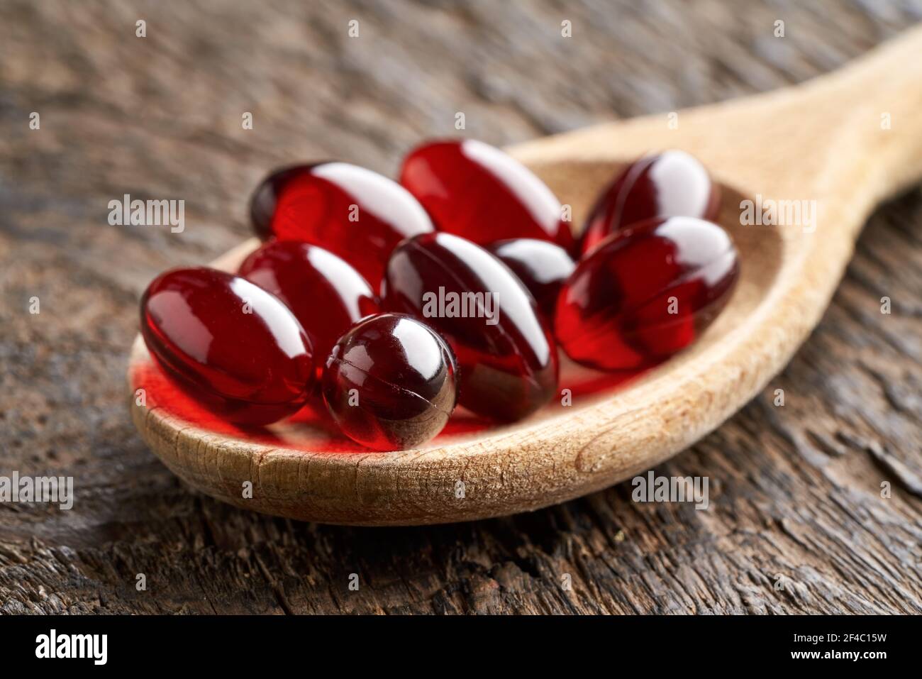 Pillole di olio di krill su un cucchiaio, closeup Foto Stock
