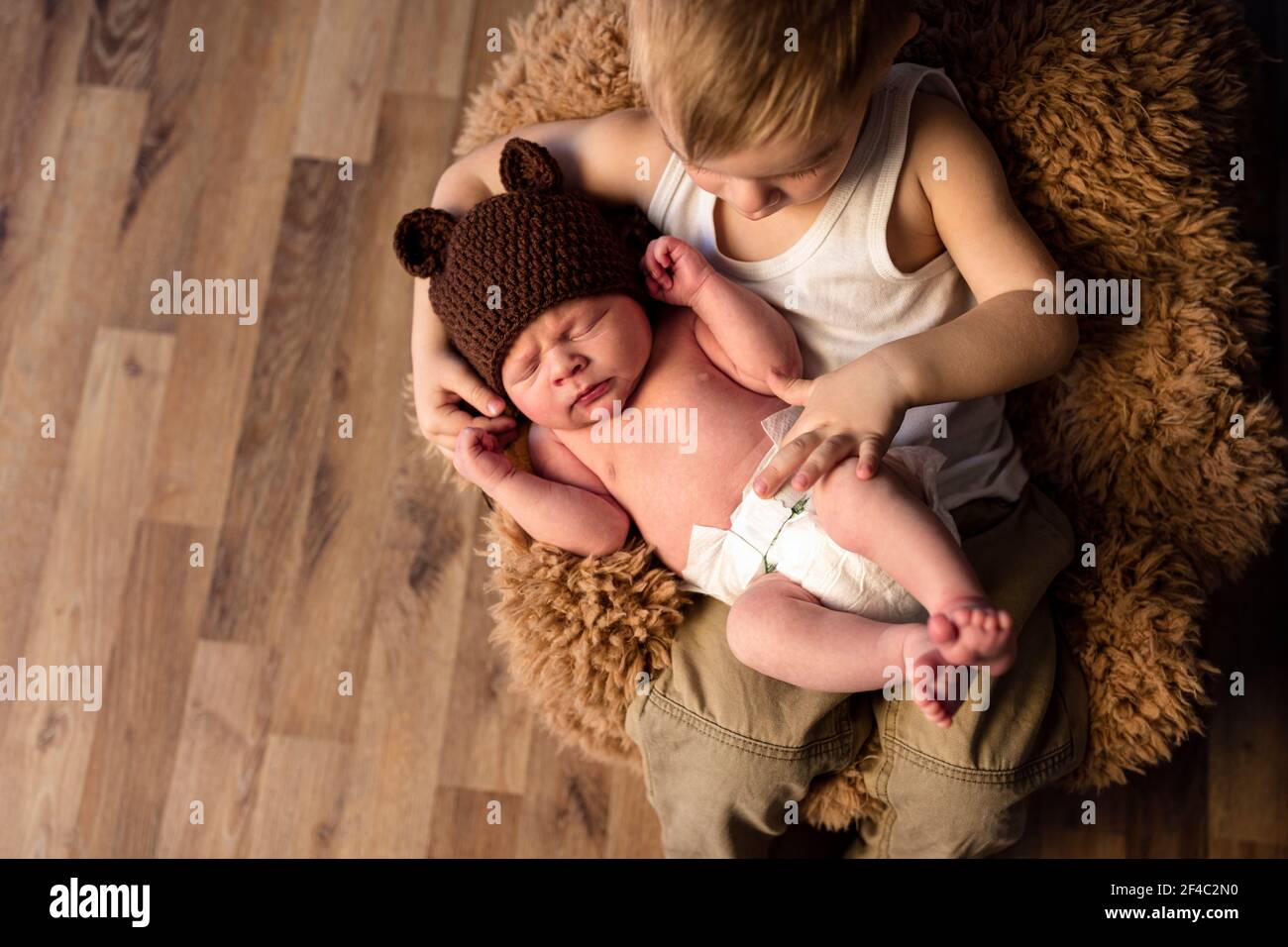 Ragazzino che guarda il neonato addormentato fratello, l'amore e la famiglia Foto Stock