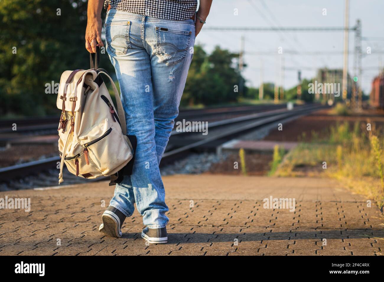 Backpacker in attesa di treno alla stazione ferroviaria. Viaggio turistico in treno. Foto Stock