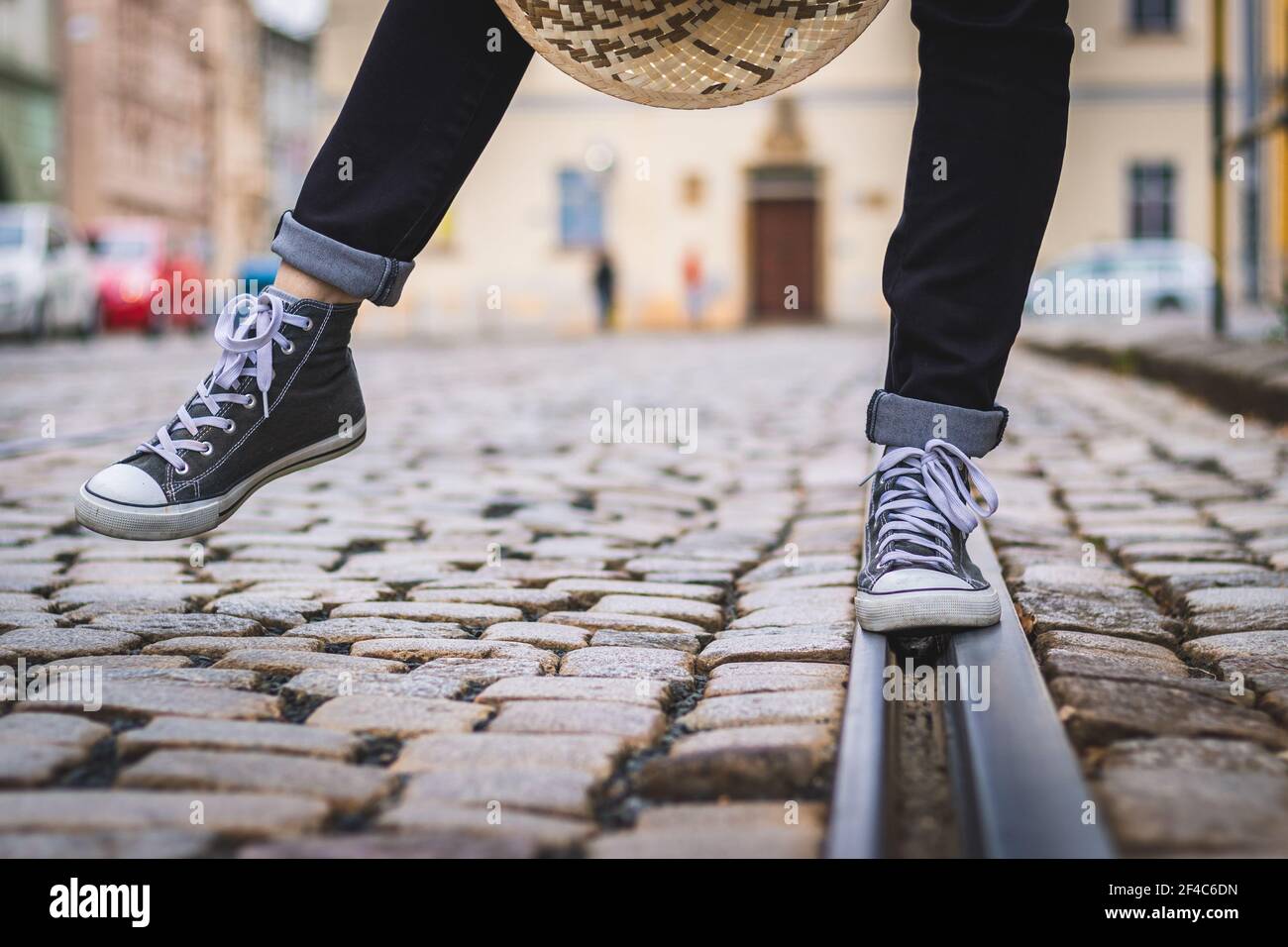 La donna indossa scarpe da ginnastica e cammina per la strada. Gambe umane con scarpe in tela. Foto Stock