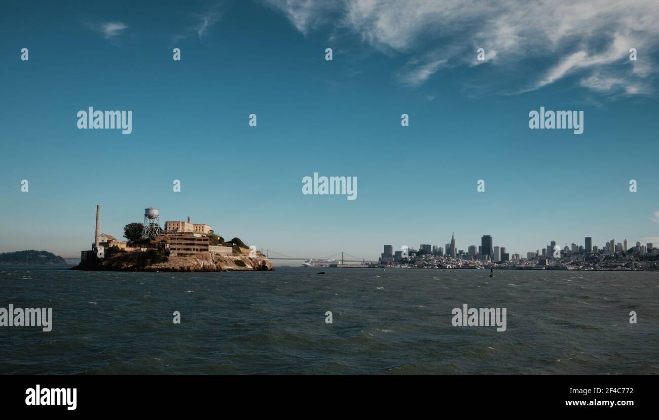 Le nuvole galleggiano sopra la baia mentre il sole splende sull'isola di Alcatraz a San Francisco, California. Foto Stock