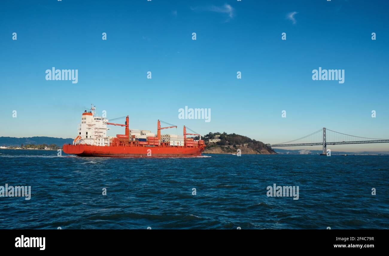 Una nave portacontainer si avvicina al Bay Bridge nella Baia di San Francisco. Foto Stock