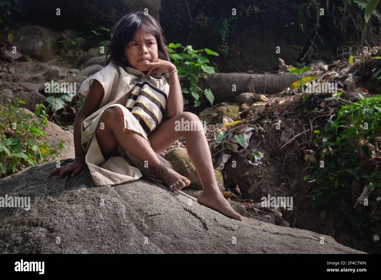 Un ragazzo Kogi si rilassa su un masso nella giungla di la Guajira, Colombia. Foto Stock