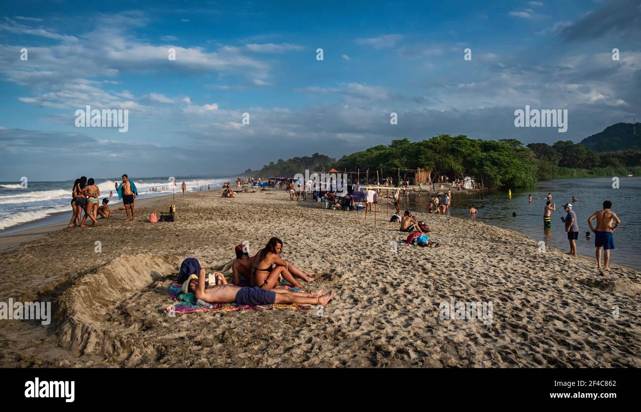 La gente gode la spiaggia vicino al tramonto a Palomino, Colombia. Foto Stock