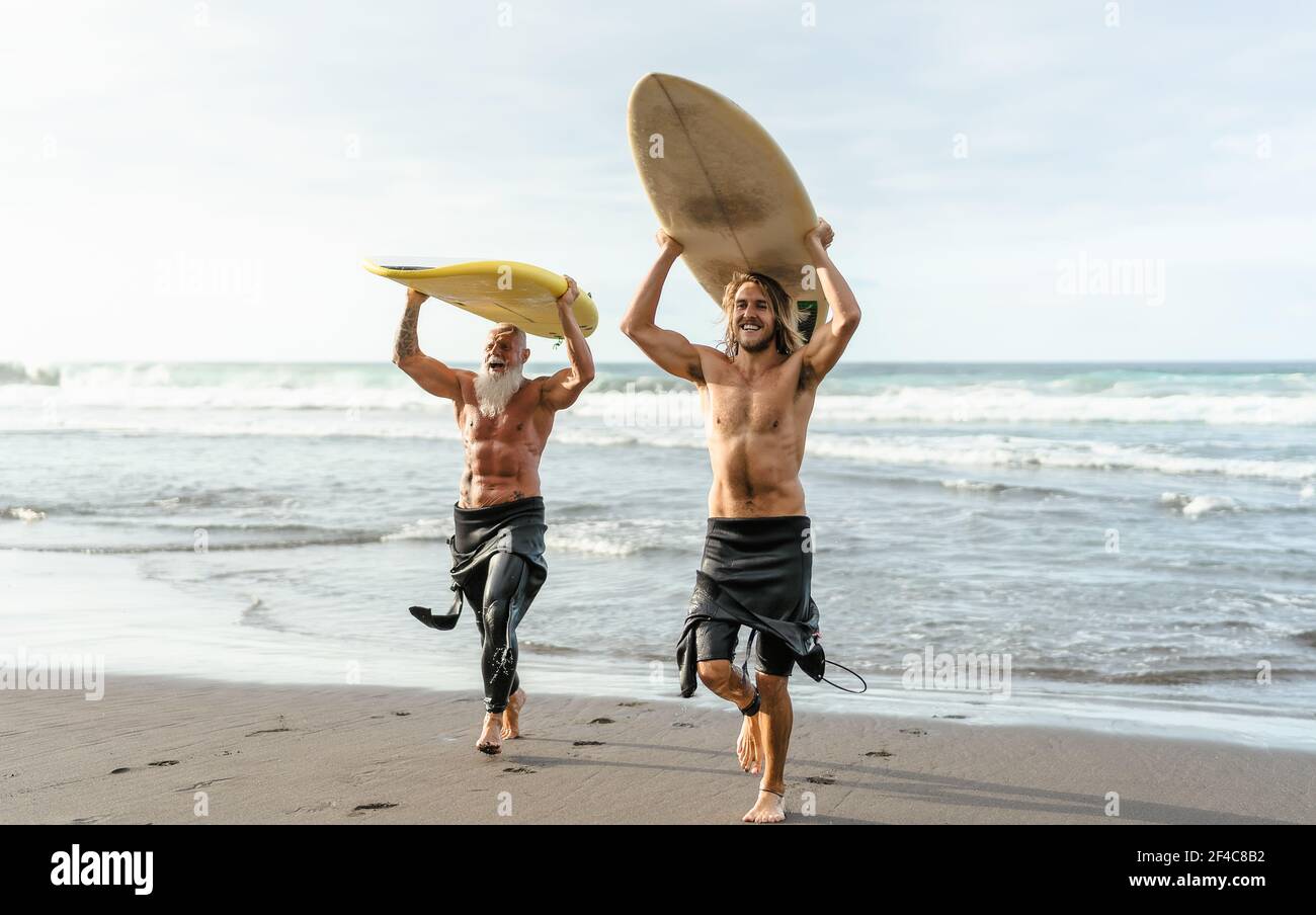 Amici felici con diverse età surf insieme - persone sportive Divertirsi durante la giornata di surf in vacanza - stile di vita sportivo estremo concetto Foto Stock