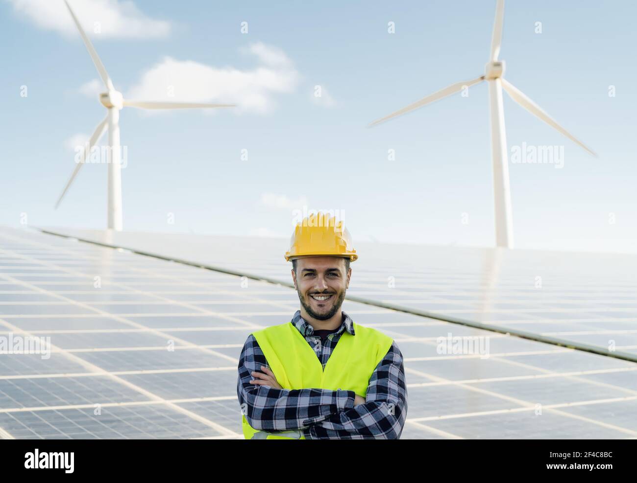 Giovane ingegnere maschile che lavora per l'energia alternativa con turbina eolica E pannelli fotovoltaici - innovazione e concetto di energia verde Foto Stock