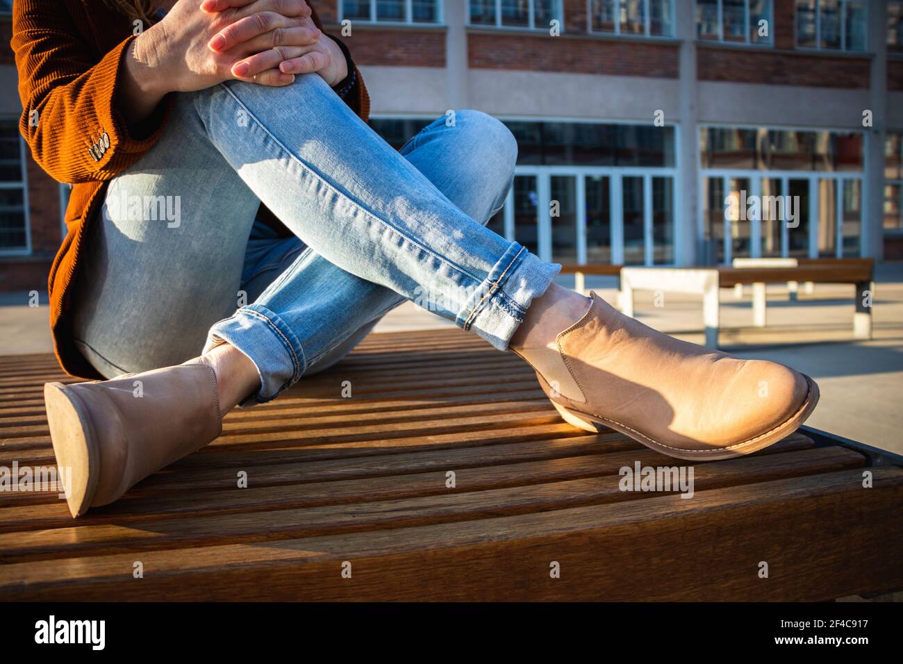 Donna in abbigliamento casual durante la pausa in città. Donna alla moda  seduta sulla panca. Relax nella città moderna Foto stock - Alamy