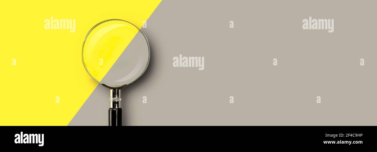 Lente di ingrandimento su sfondo giallo-grigio colorato con posizione per il testo. Foto Stock