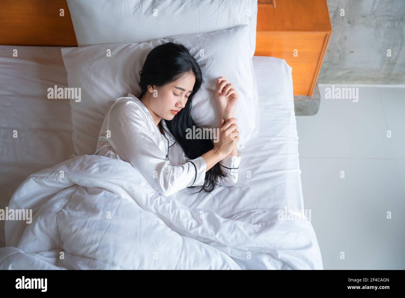 Vista dall'alto della bella giovane donna asiatica che dorme bene nel letto. Ragazza adolescente che riposa, buon concetto di sonno notturno. Foto Stock