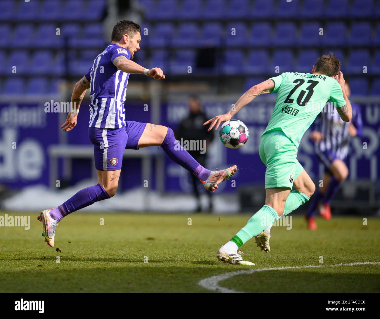 Aue, Germania. 20 Marzo 2021. Calcio: 2. Bundesliga, FC Erzgebirge Aue - SV Sandhausen, Matchday 26, a Erzgebirgsstadion. Pascal Testroet (l) di Aue segna contro Nils Röseler di Sandhausen per renderlo 2:0. Credito: Robert Michael/dpa-Zentralbild/dpa - NOTA IMPORTANTE: In conformità con le norme del DFL Deutsche Fußball Liga e/o del DFB Deutscher Fußball-Bund, è vietato utilizzare o utilizzare fotografie scattate nello stadio e/o della partita sotto forma di sequenze fotografiche e/o serie fotografiche di tipo video./dpa/Alamy Live News Foto Stock
