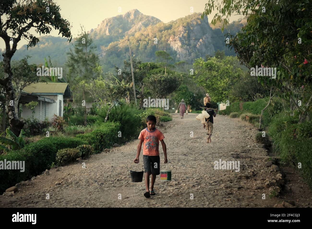 Abitanti di un villaggio che prendono acqua da una fonte di comunità nel villaggio di Fatumnasi, Timor Ovest, provincia di Nusa Tenggara Est, Indonesia. La partecipazione delle comunità alla gestione delle risorse idriche deve essere aumentata. Secondo l'Water in their Summary Progress Update 2021 pubblicato il 1 marzo 2021 a Ginevra, solo 14 paesi su 109 riferiscono di avere elevati livelli di partecipazione delle comunità al processo decisionale in materia di acqua e servizi igienico-sanitari. Foto Stock