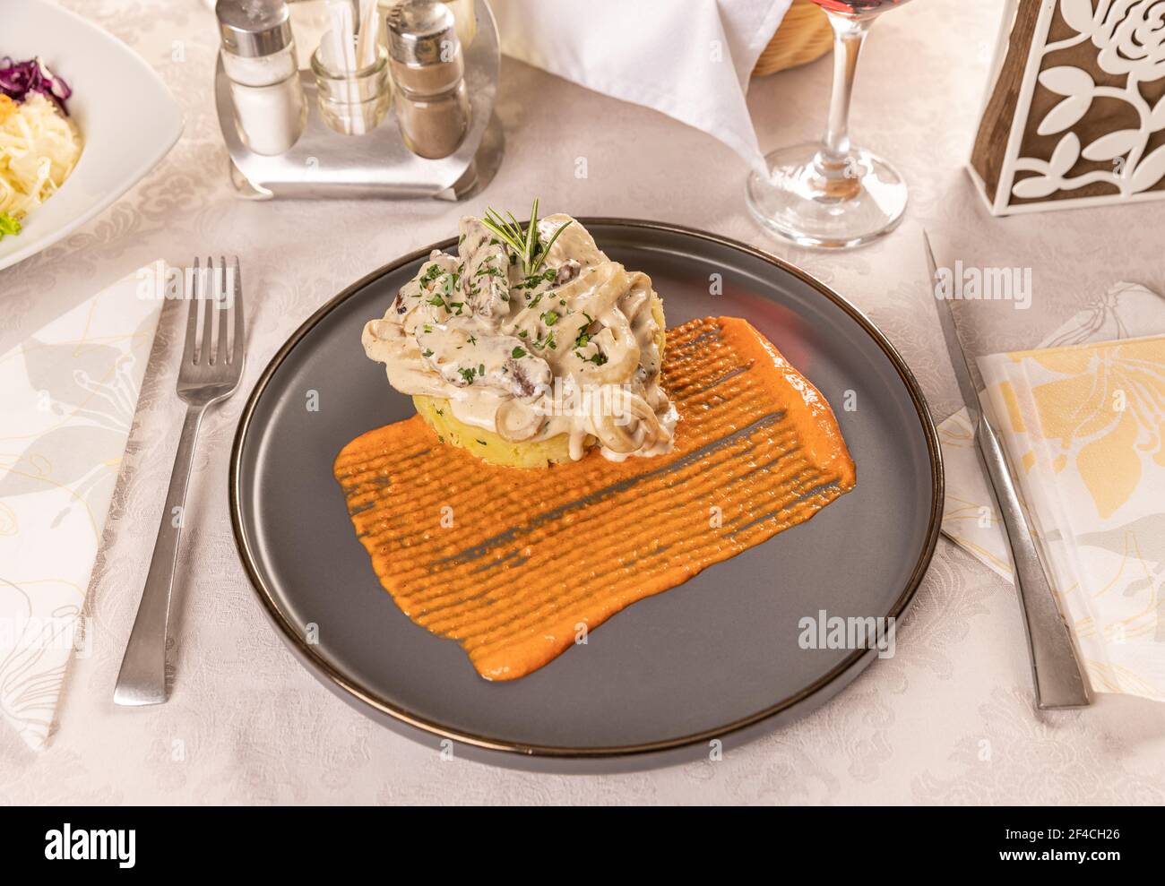 Manzo stufato con panna acida e salsa di senape servita con gratin di patate Foto Stock