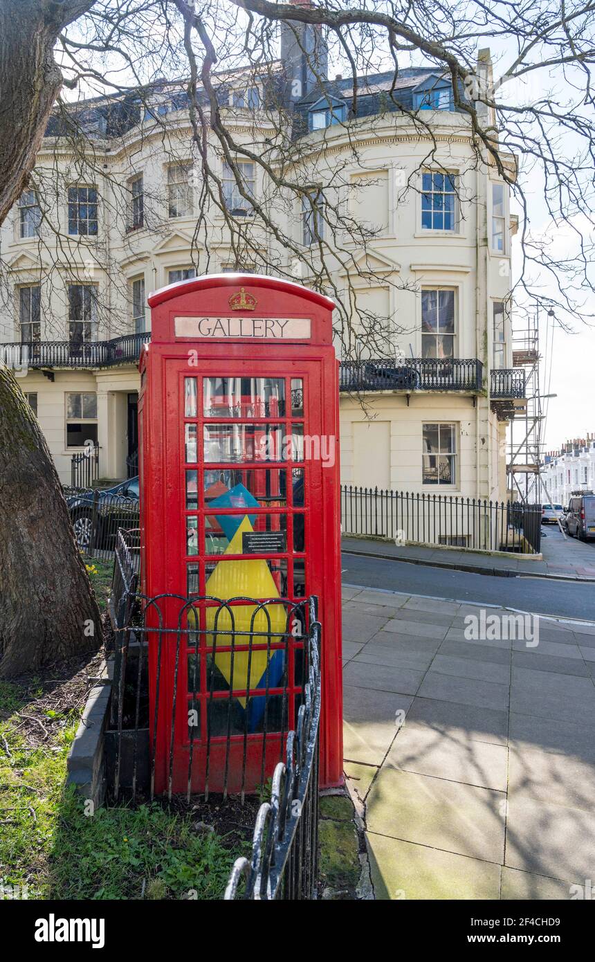 Brighton UK 20 marzo 2021 - la galleria d'arte del cane e delle ossa a Powis Square Brighton in una calda giornata di primavera lungo la costa meridionale . Questa settimana mostra all'interno delle vecchie scatole telefoniche rosse convertite, che sono il più piccolo spazio artistico di Brighton è da artista contemporaneo e illustratore, Amber Elise : Credit Simon Dack / Alamy Live News Foto Stock