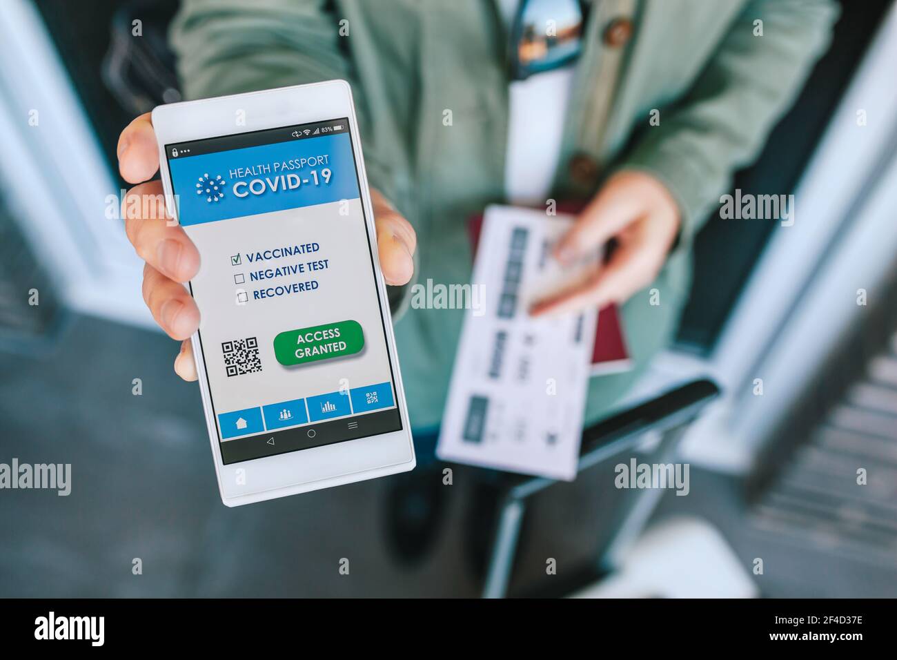 Donna che mostra il passaporto covid sullo smartphone in un aeroporto controllo Foto Stock