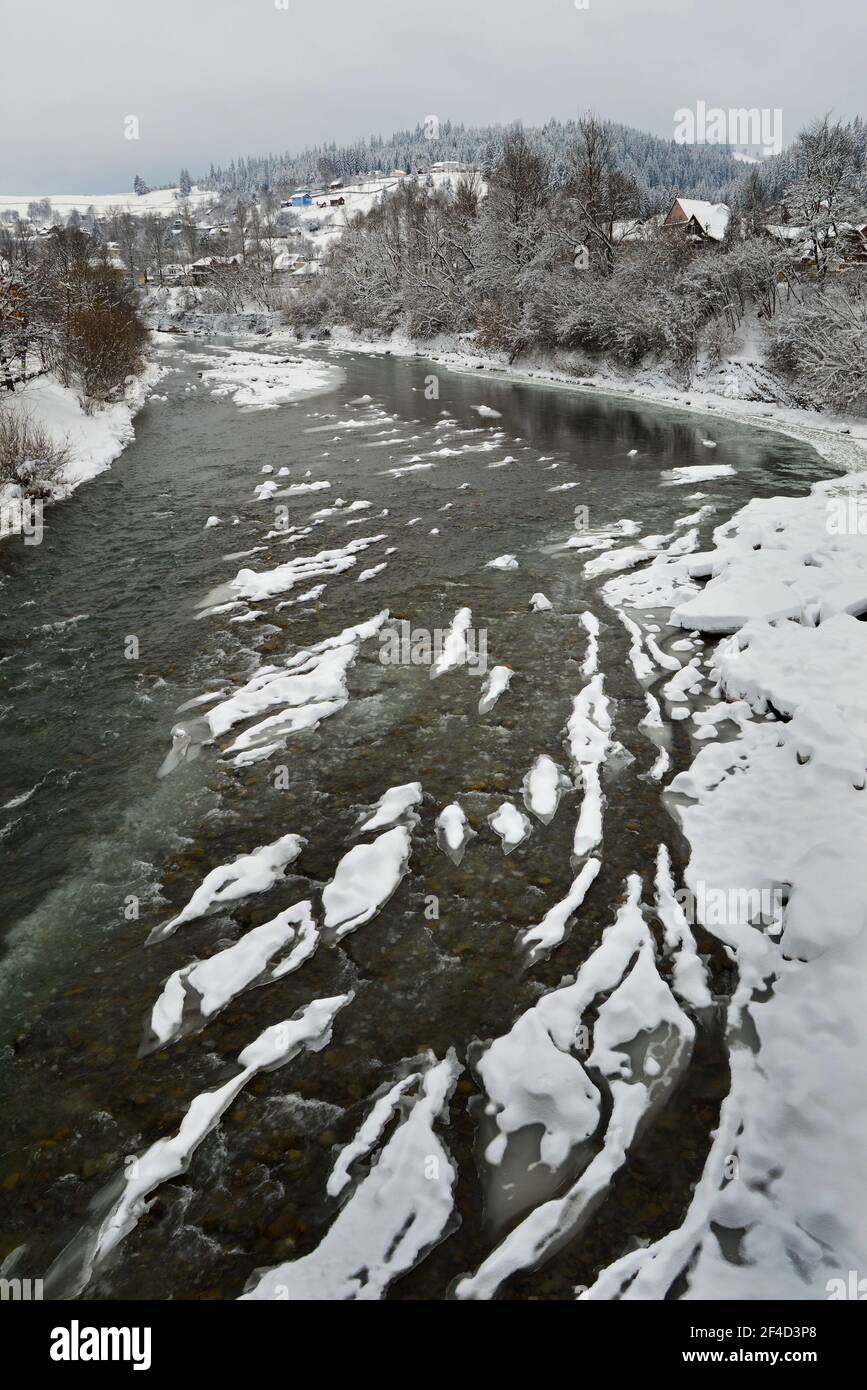 Il fiume Cheremosh nero di Verkhovyna è coperto di ghiaccio e neve. Ucraina Foto Stock