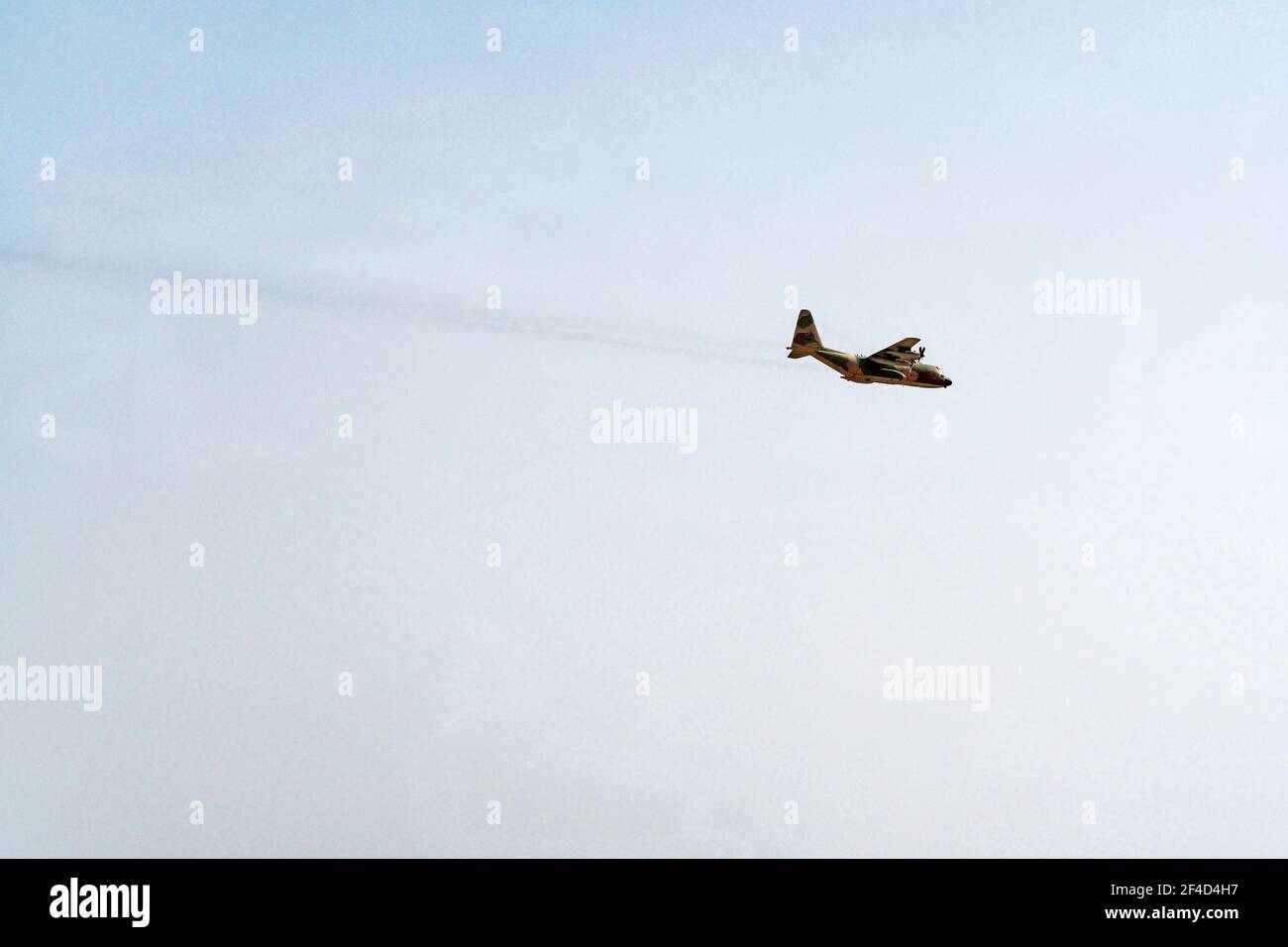 un aereo di trasporto aereo militare camuffato in volo sopra il deserto di negev in un cielo blu chiaro che mostra il flusso del getto di scarico Foto Stock