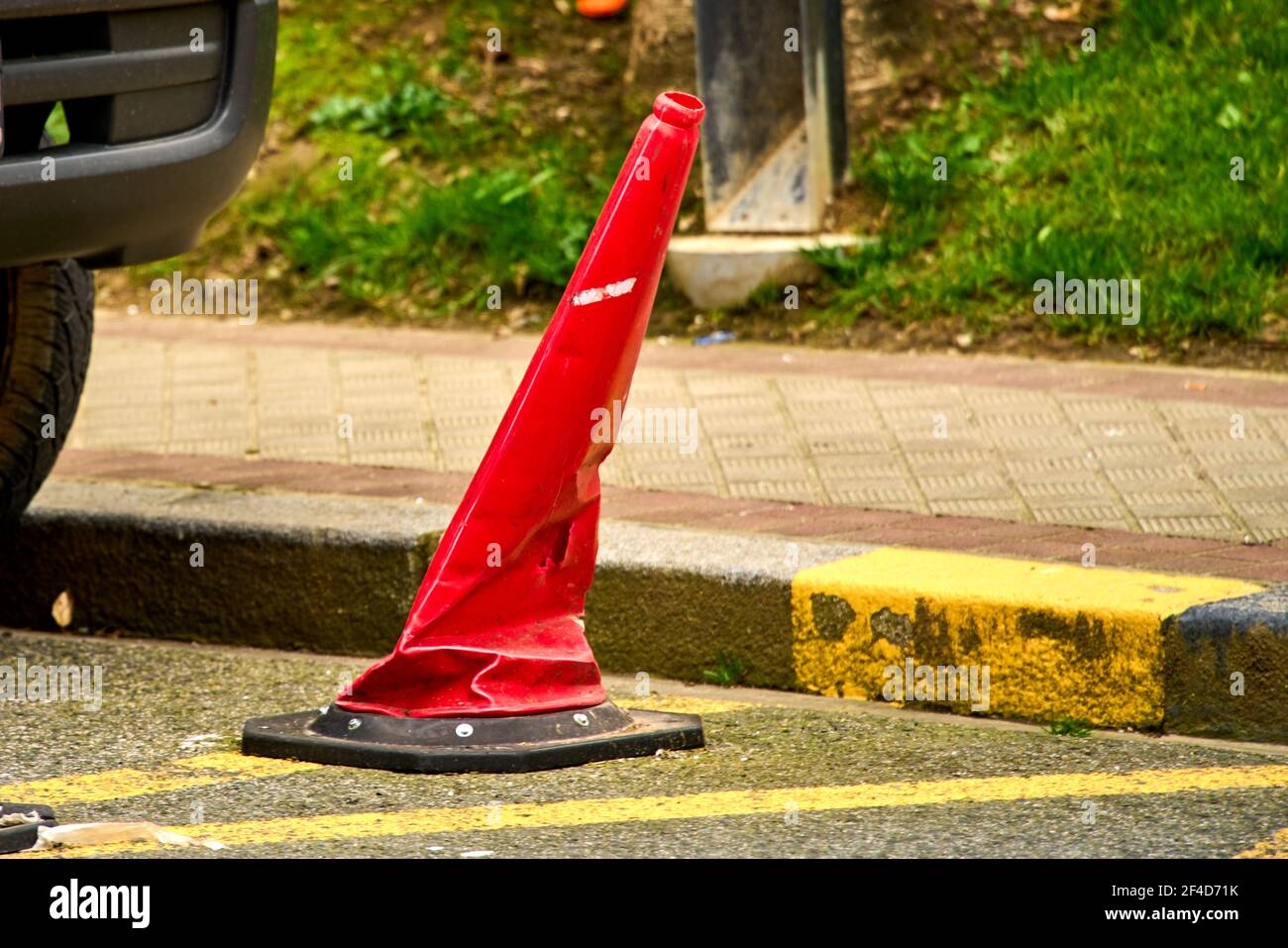 Cono di traffico arancione schiacciato dall'azione di qualche auto Foto Stock