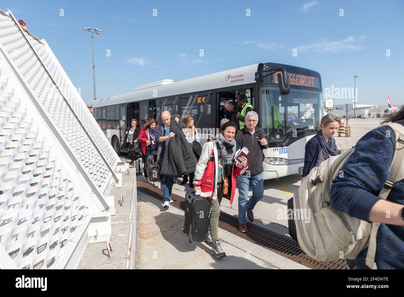 Passeggeri che lasciano l'autobus di trasporto tra il terminal e l'aereo, aeroporto di Cardiff, Galles, Regno Unito Foto Stock