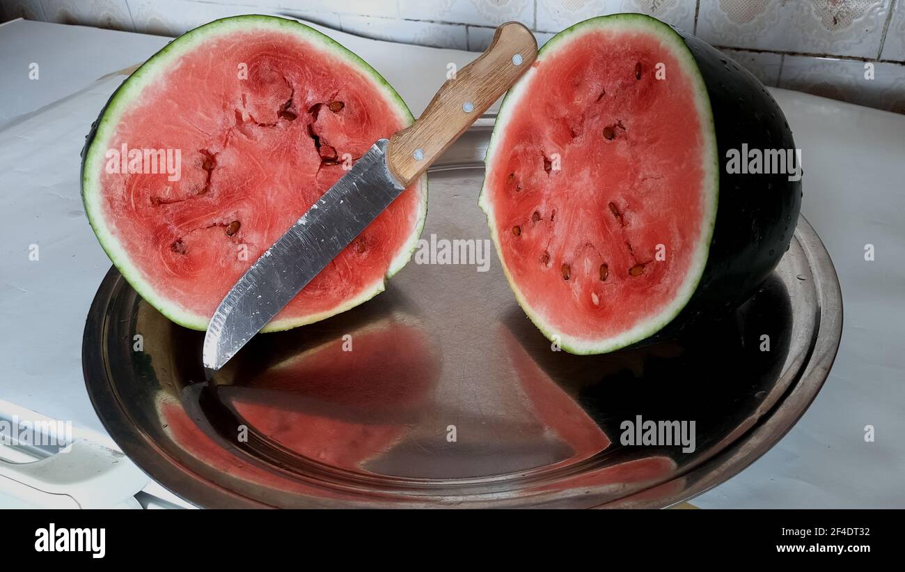 Due metà di un cocomero maturo tagliato su un vassoio Foto Stock