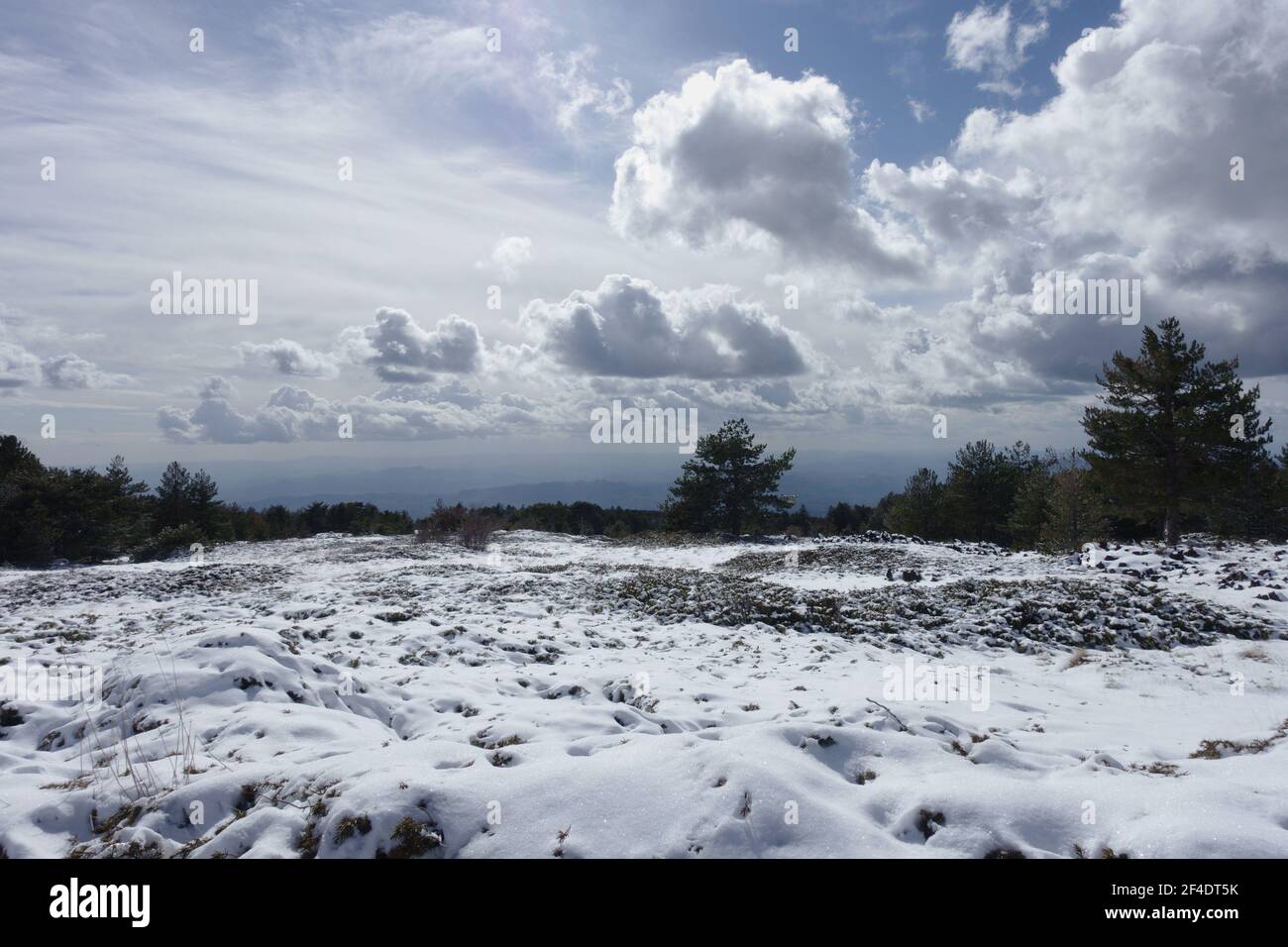 Vecchia pianura lavica innevata in Sicilia cumulo nubi a. L'orizzonte nel Parco dell'Etna Foto Stock