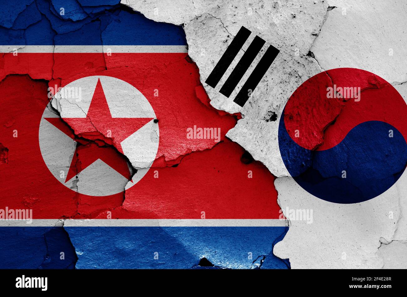 Bandiere della Corea del Nord e della Corea del Sud dipinte su incrinature parete Foto Stock