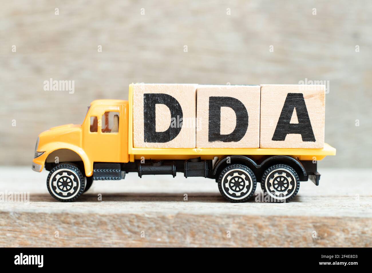 Carrello giocattolo tenere alfabeto blocco di lettere in parola DDA (abbreviazione di ammortamento, esaurimento e ammortamento o conto deposito domanda) su legno backgrou Foto Stock
