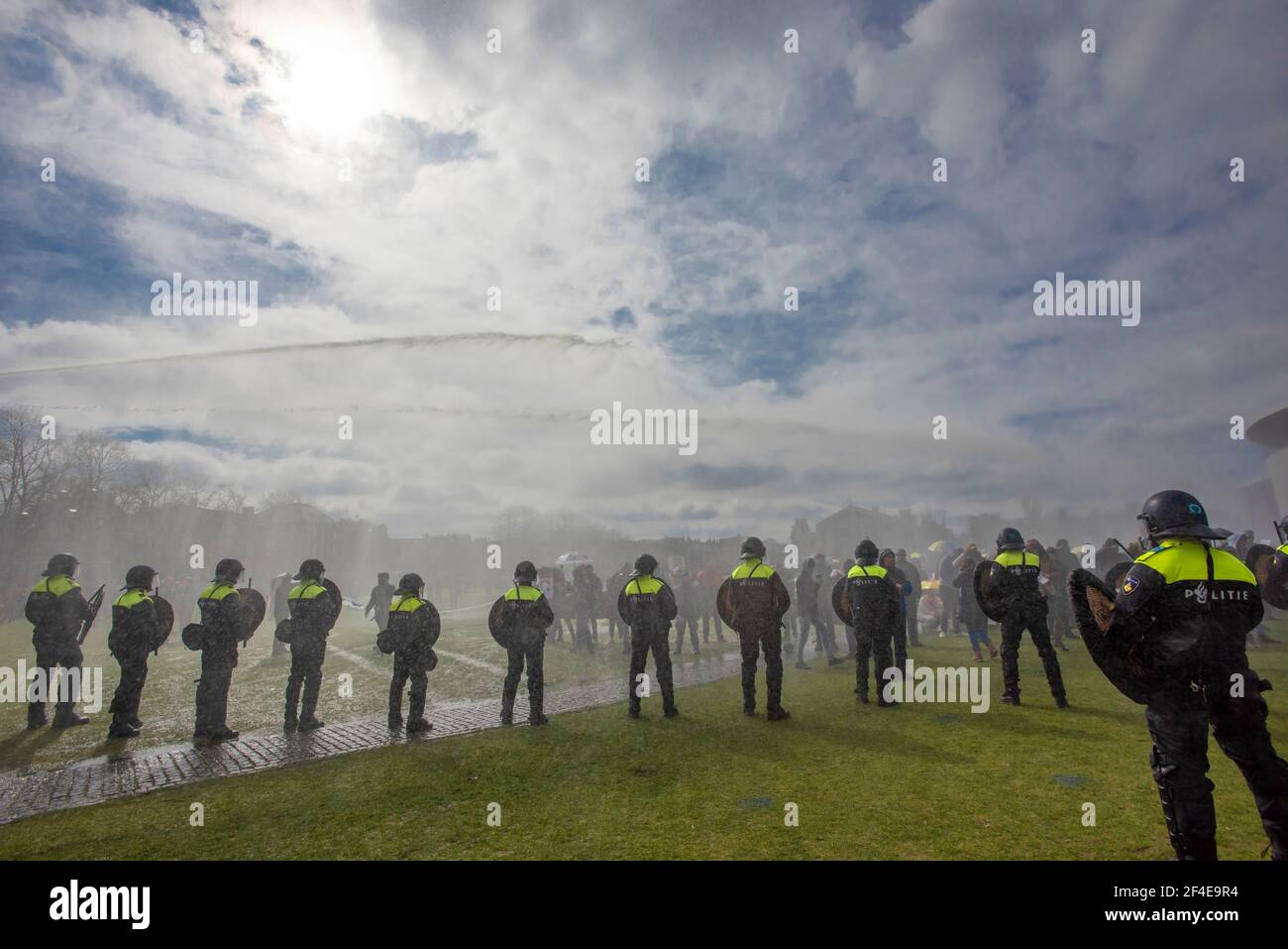 Museumplein, Amsterdam. Sabato 20 marzo, 2021. Amore, libertà, non dittatura' è stato il canto principale per la dimostrazione di oggi. Centinaia di persone si sono riunite questo pomeriggio per protestare contro le misure di Corona o Covid-19, non si sono conservate a distanza sociale e difficilmente un facemask in vista. La manifestazione illegale si è conclusa sulla Museumplein con l'introduzione di due Water-canon dopo numerosi annunci verbali di disperdere è andato senza ascolto. La polizia ha diviso il gruppo stimato di 1400 persone e li ha condotti nella zona di Leidsekade ad Amsterdam. Credit: Charles M Vella/Alamy Live News Foto Stock