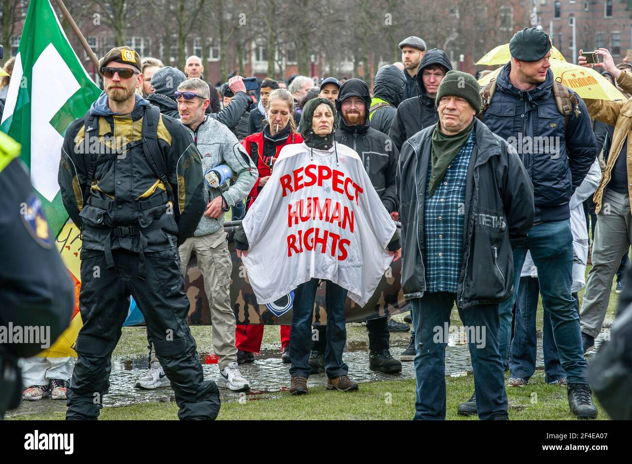 Museumplein, Amsterdam. Sabato 20 marzo, 2021. Amore, libertà, non dittatura' è stato il canto principale per la dimostrazione di oggi. Centinaia di persone si sono riunite questo pomeriggio per protestare contro le misure di Corona o Covid-19, non si sono conservate a distanza sociale e difficilmente un facemask in vista. La manifestazione illegale si è conclusa sulla Museumplein con l'introduzione di due Water-canon dopo numerosi annunci verbali di disperdere è andato senza ascolto. La polizia ha diviso il gruppo stimato di 1400 persone e li ha condotti nella zona di Leidsekade ad Amsterdam. Credit: Charles M Vella/Alamy Live News Foto Stock