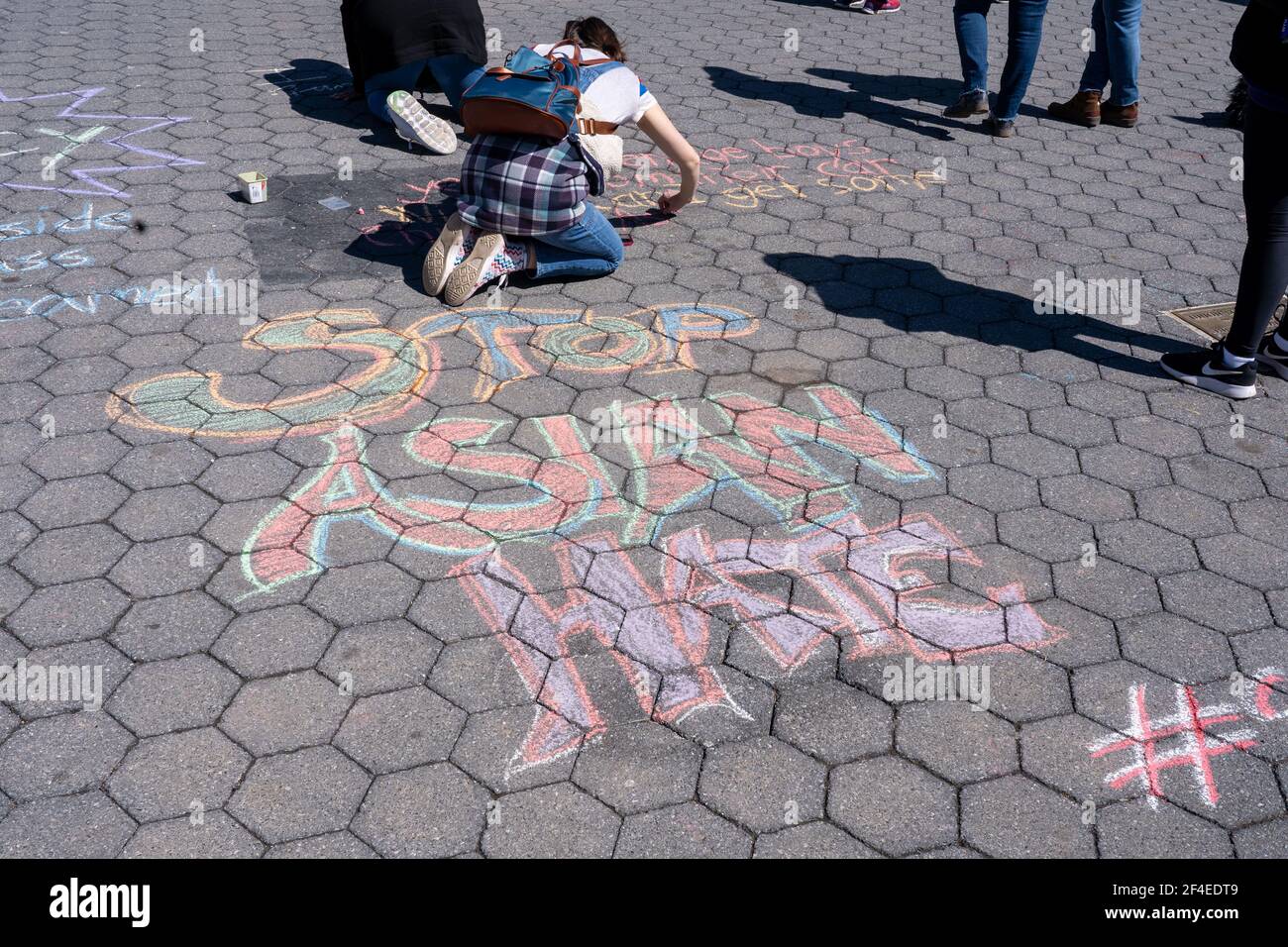 NEW YORK, NY - MARZO 20: Gli studenti scrivono messaggi in gesso sul marciapiede chiamando a fermare l'odio asiatico in Union Square Park il 20 Marzo 2021 a New York City. Il 16 marzo otto persone sono state uccise in tre centri termali di Atlanta, Georgia, sei delle quali erano donne asiatiche, in un attacco che ha mandato il terrore attraverso la comunità asiatica. Credit: Ron Adar/Alamy Live News Foto Stock