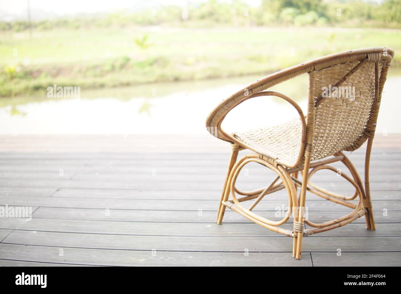 sedia in rattan in vimini sul balcone terrazzo patio per riposare vicino stagno Foto Stock