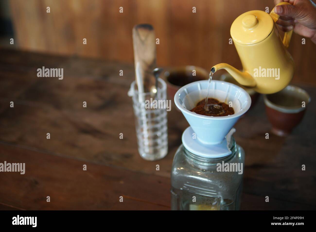 barista preparazione del caffè con macchina per il caffè e bollitore. Gocciolamento di caffè macinato con filtro Foto Stock