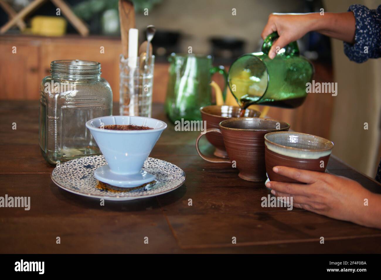 barista preparazione del caffè con macchina per il caffè e bollitore. Gocciolamento di caffè macinato con filtro Foto Stock