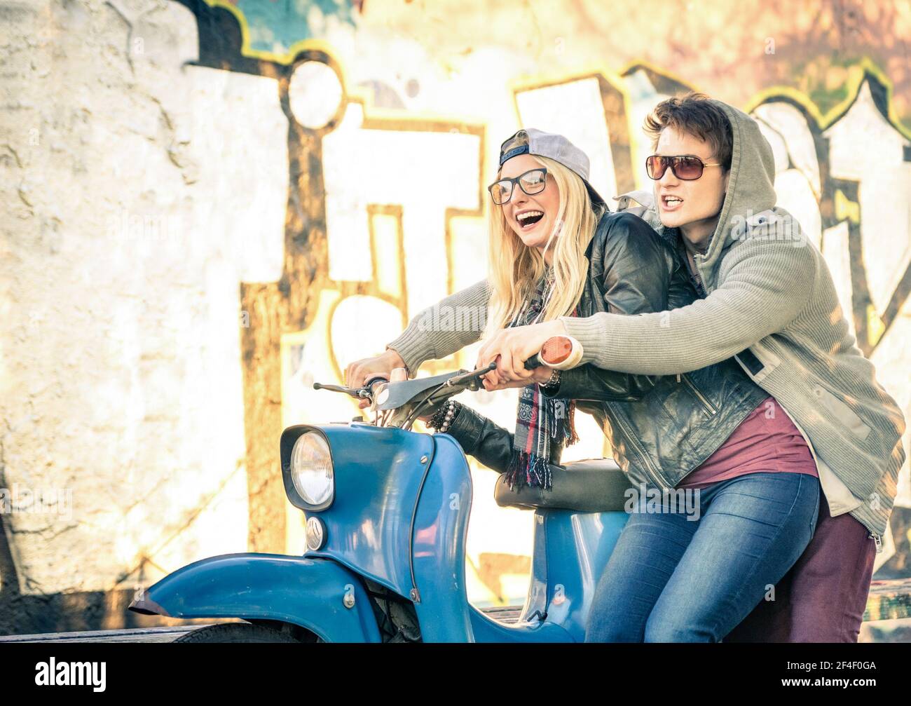 Giovane coppia di amanti che appassionano il divertimento su uno scooter d'epoca Mopied - bell'uomo in atteggiamento giocoso con il suo bello ragazza Foto Stock