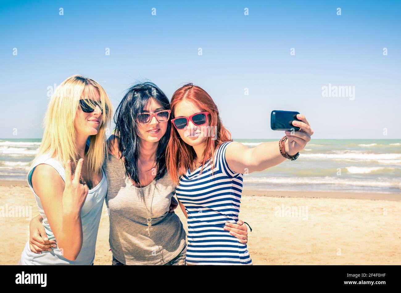 Gruppo di fidanzate che prendono un selfie alla spiaggia - Concetto di amicizia e divertimento in estate con nuovo tendenze e tecnologia Foto Stock
