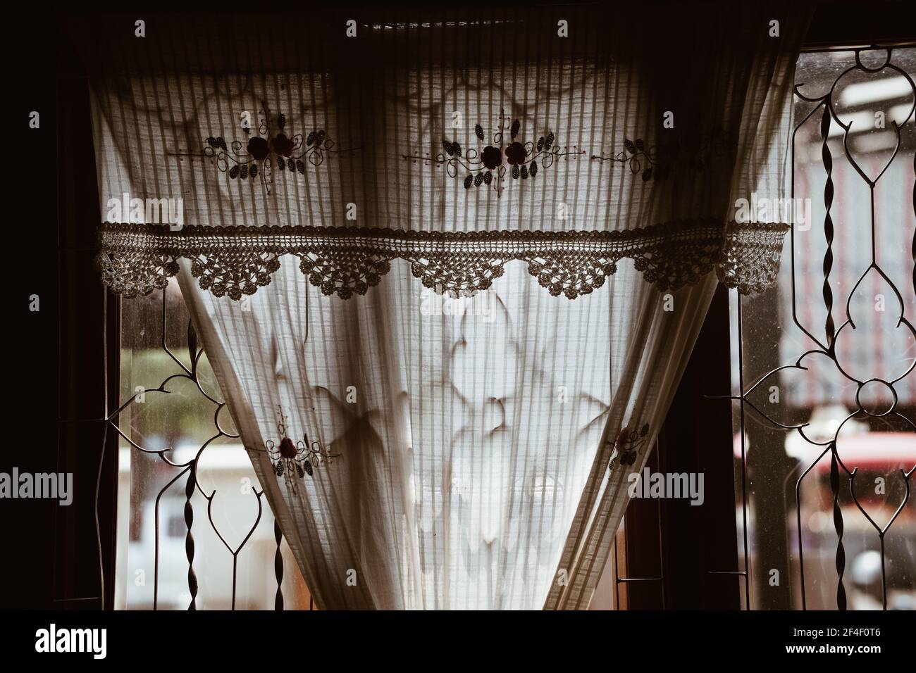 tenda in tessuto di cotone a crochet beige fatta a mano vicino alla finestra di vetro Foto Stock