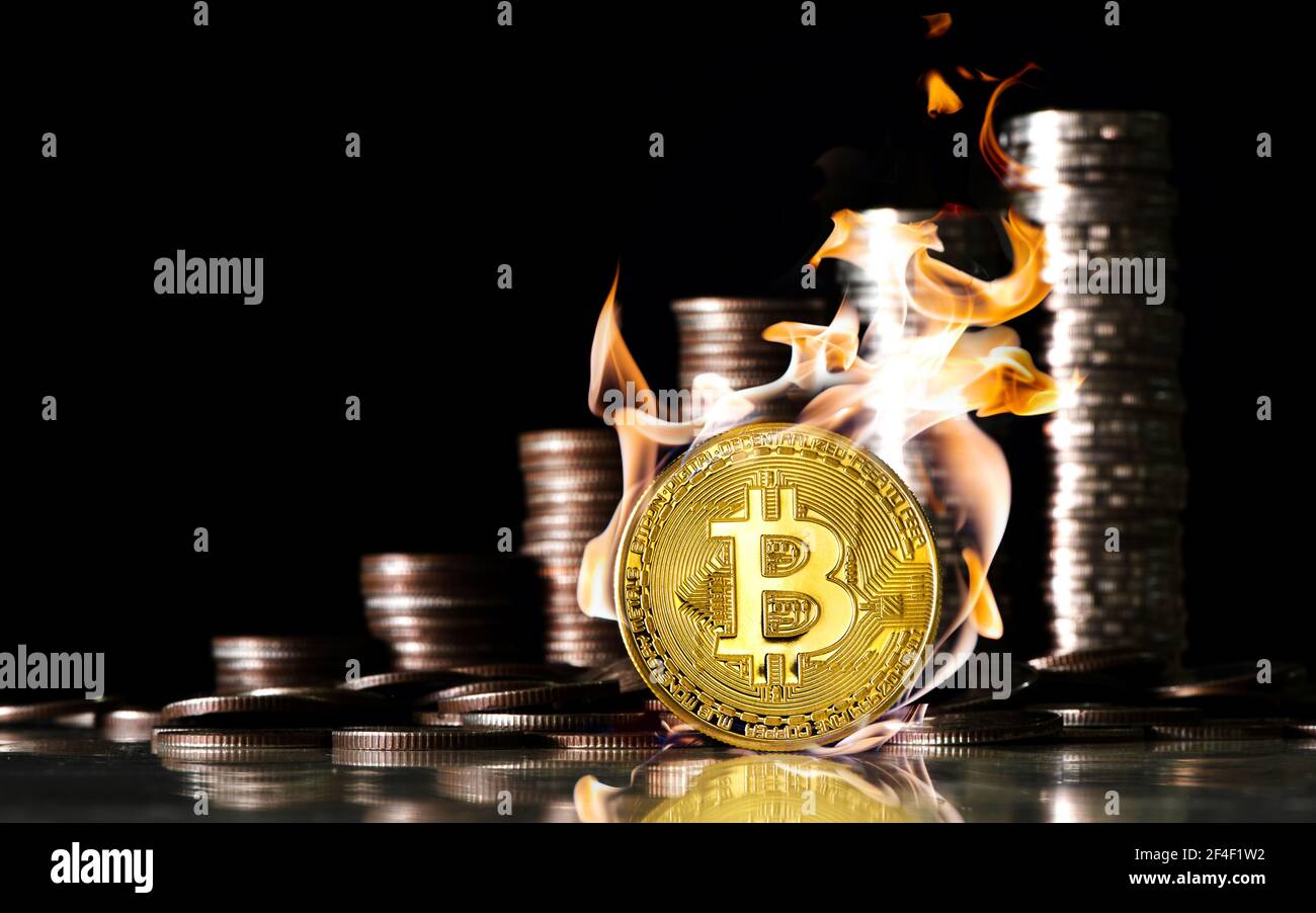 Bitcoin dentro il fuoco sullo sfondo di monete di baht. Concetto di finanza e investimento. Foto Stock