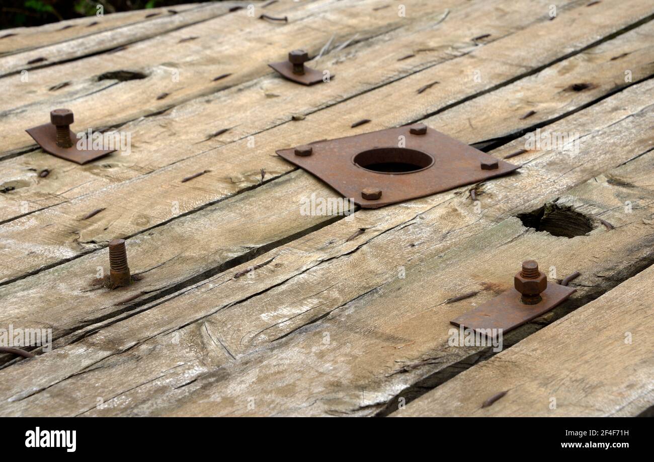 Legno intemperie e bulloni di un tamburo per cavi Foto Stock Legno intemperie e bulloni di un tamburo per cavi Foto Stock