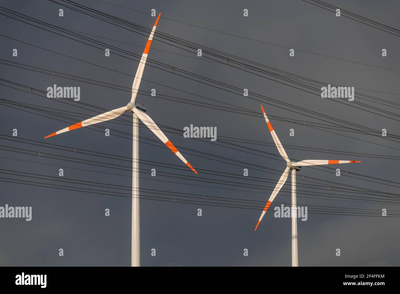 Le nubi di pioggia oscure si radunano dietro due turbine eoliche, Wolmirstedt, Sassonia-Anhalt, Germania Foto Stock