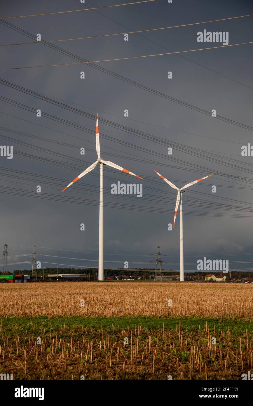 Le nubi di pioggia oscure si radunano dietro due turbine eoliche, Wolmirstedt, Sassonia-Anhalt, Germania Foto Stock