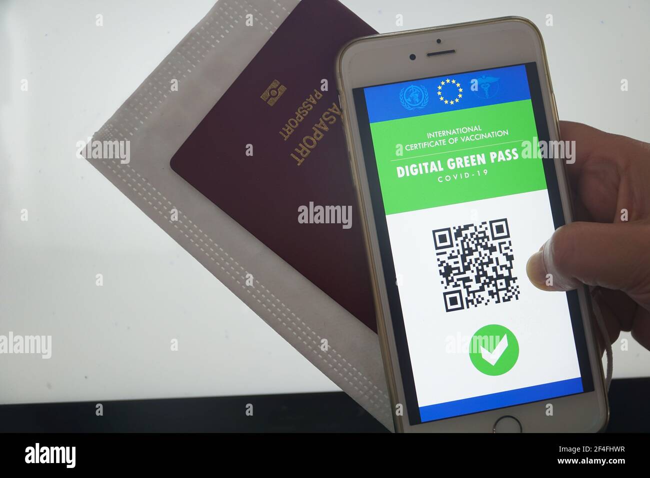 Il pass verde digitale dell'Unione europea con il codice QR sullo schermo di un telefono cellulare tenuto da una mano in aeroporto per i viaggi. Passaporto dell'immunità, Foto Stock