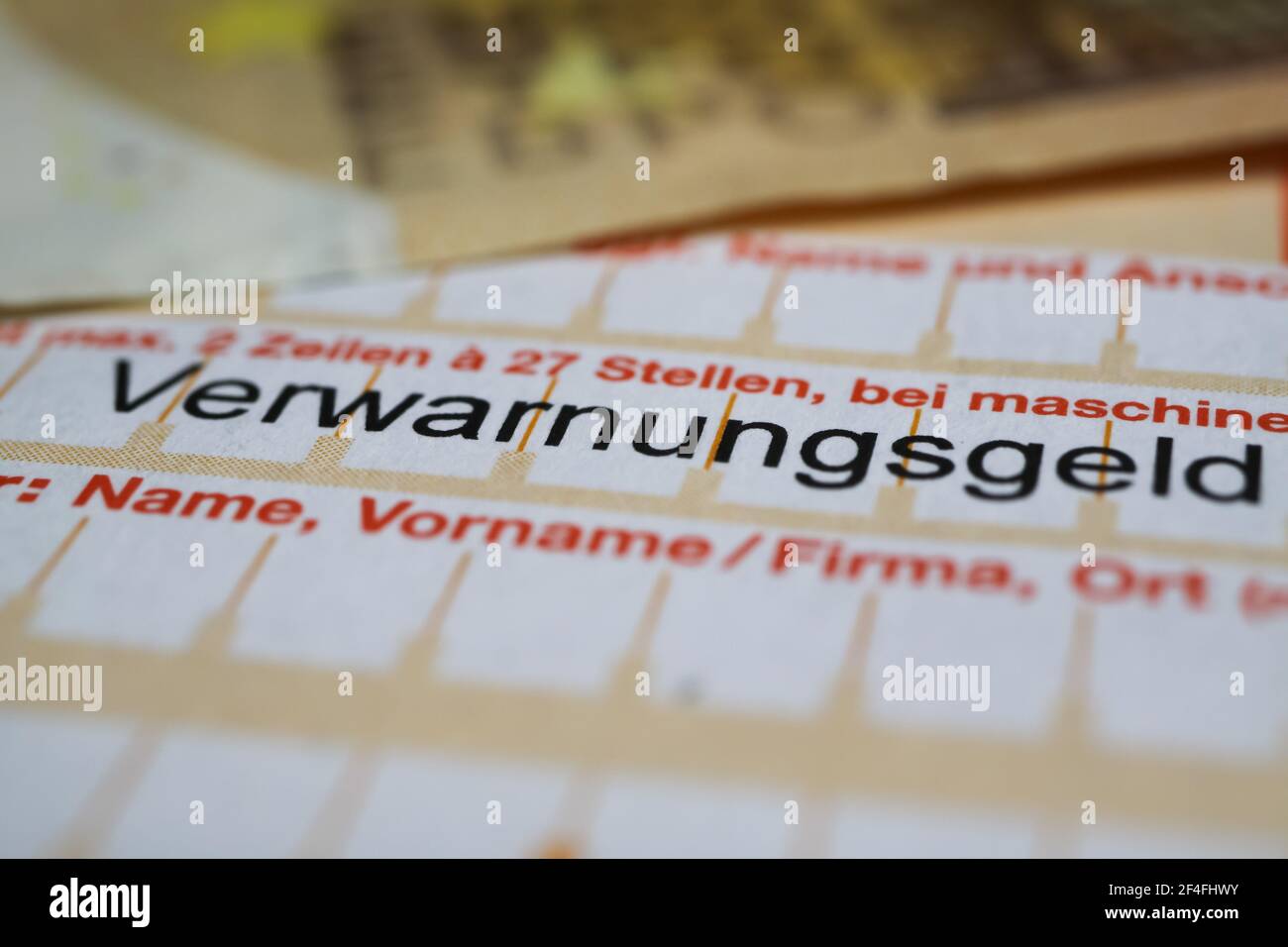 Viersen, Germania - 1 marzo. 2021: Makro closeup del modulo di bonifico bancario tedesco con biglietto di velocità (verwarnungsgeld) con banconote in euro Foto Stock