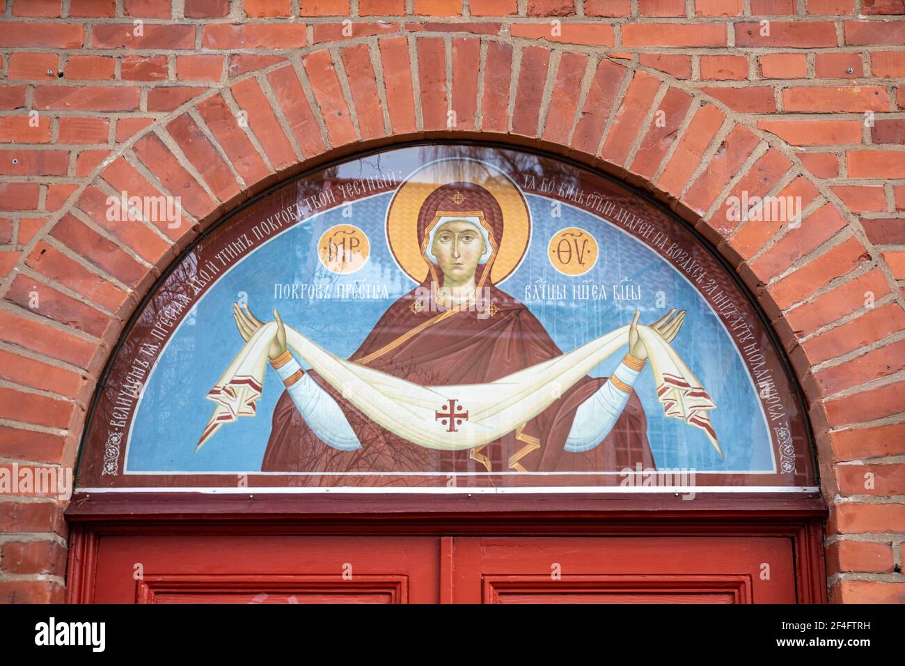 Maria la Santa Madre di Dio raffigurata in stile russo sopra le porte della Chiesa ortodossa orientale Pokrova a Munkkiniemi, Helsinki, Finlandia Foto Stock