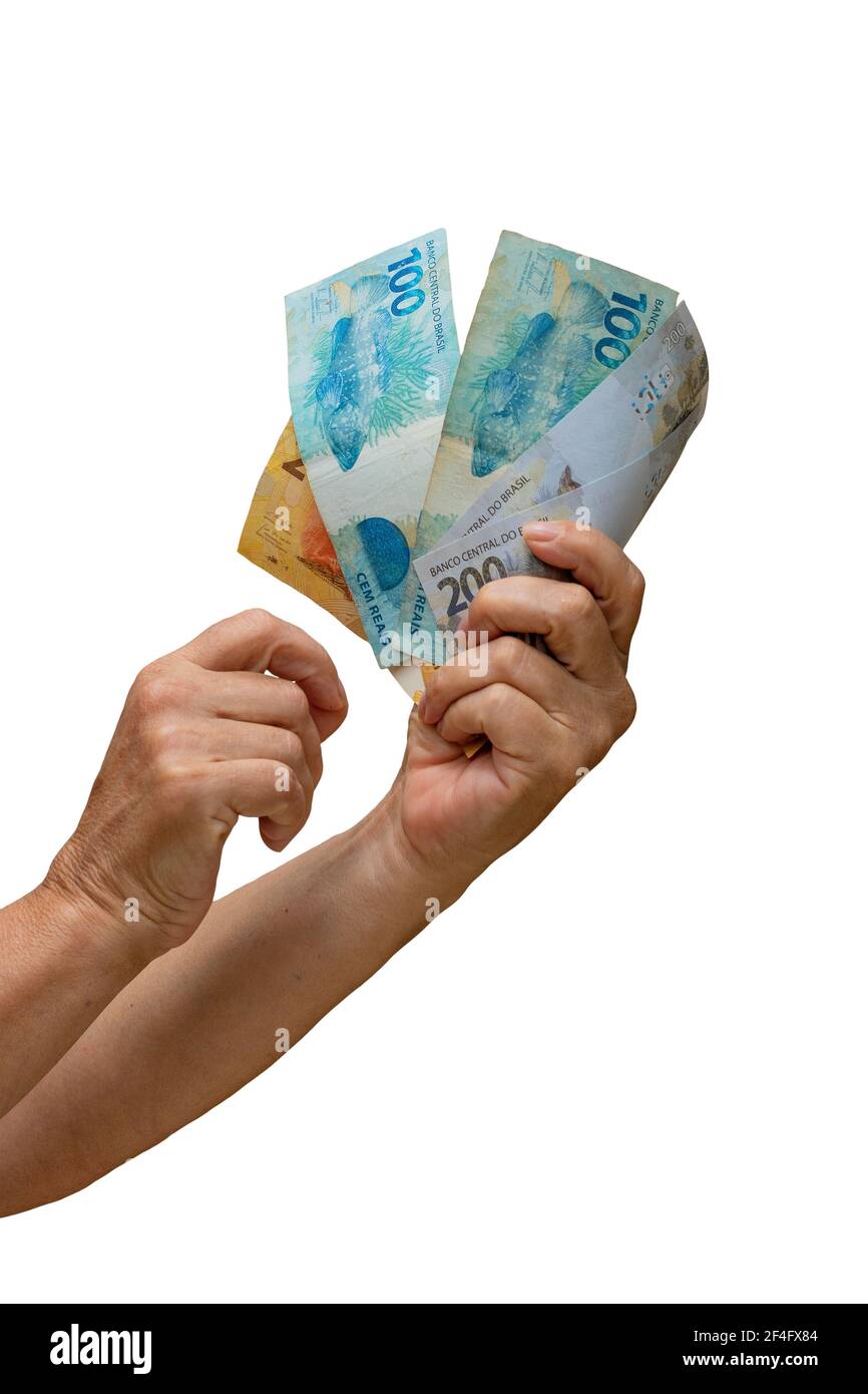 Tenendo denaro brasiliano reale, bollette di 200, 100, 50 e 20 isolato su sfondo bianco. Foto Stock