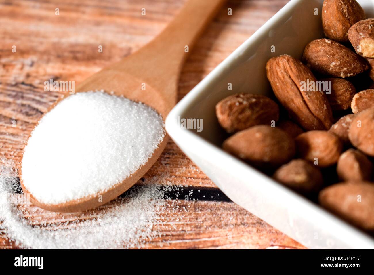 Mandorle salate in una ciotola su un tavolo di legno Foto Stock